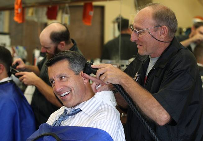 Barber Don Diehl cuts Gov. Brian Sandoval's hair, in Sparks, Nev., on Thursday, Oct. 14, 2014. Sandoval says going to the Paradise Park Barber Shop is a family tradition. .Photo by Cathleen Allison