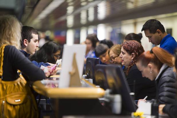 Travelers check in at the Allegiant Airlines counter Thursday, Oct. 30, 2014, at McCarran International Airport. Allegiant is charging a $5 fee for printing boarding passes at the airport. The $5 charge boosted sagging quarterly earnings.