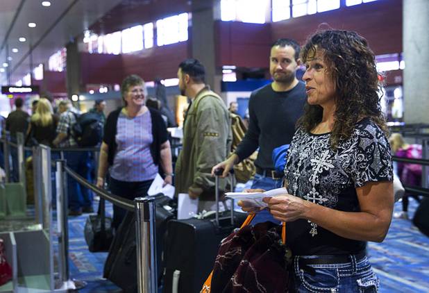 Marian Sinner, right, waits to check-in at the Allegiant Airlines  counter in McCarran International Airport Thursday, Oct. 30, 2014. Allegiant is charging a $5 fee for printing boarding passes at the airport.