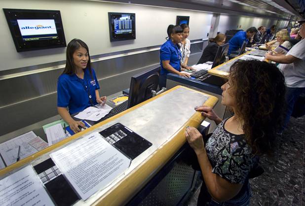 A ticketing agent helps Marian Sinner check-in at the Allegiant Airlines counter in McCarran International Airport Thursday, Oct. 30, 2014. Allegiant is charging a $5 fee for printing boarding passes at the airport.