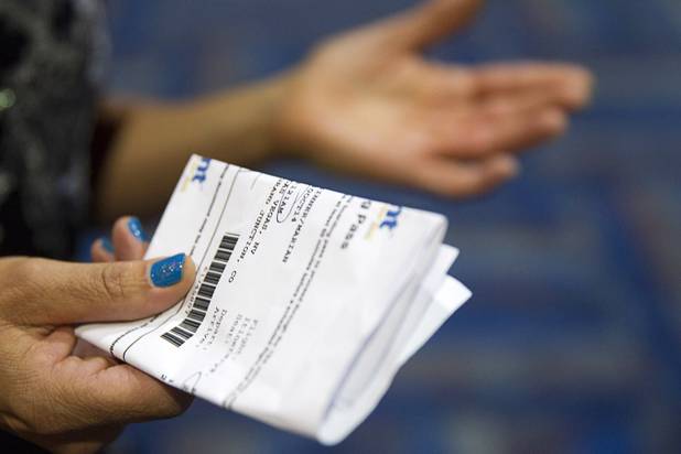 Marian Sinner holds her boarding pass at the Allegiant Airlines check-in counter in McCarran International Airport Thursday, Oct. 30, 2014. Sinner avoided a $5.00 fee by printing a boarding pass before coming to the airport.