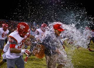 Arbor View head coach Dan Barnson is blasted with a cooler of water after his team beat Centennial 20-16 on Thursday, October 30, 2014.