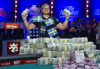 Martin Jacobson, 27, of Sweden stands with cash after beating Felix Stephensen of Norway to win the $10 million first-place prize during the 2014 World Series of Poker Main Event Final Table on Tuesday, Nov. 11, 2014, at the Rio.  