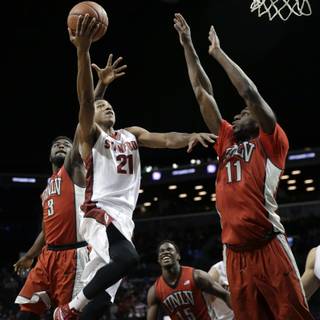 Stanford's Anthony Brown, second from left, drives to the basket past UNLV's Jordan Cornish, left, and Goodluck Okonoboh, right, during the second half of an NCAA college basketball game in the Coaches vs. Cancer Classic in New York, Friday, Nov. 21, 2014. Stanford defeated UNLV 89-60. (AP Photo/Seth Wenig)