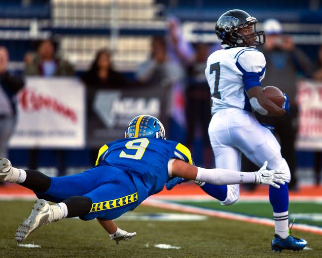 Desert Pines Isaiah Morris #7 avoids a diving tackle by Moapa Valley's Derek Cope #9 during the Division I-A state high school football championship game on Saturday, November 22, 2014.