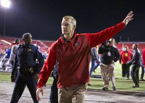 UNLV head coach Bobby Hauck waves goodbye to the crowd as he walks off the field for the last time at Sam Boyd Stadium on Saturday, Nov. 29, 2014. 
