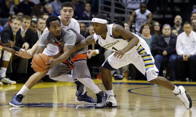 Tennessee-Martin's Deville Smith tries to get away from Marquette's Sandy Cohen III and Duane Wilson (1) during the first half of an NCAA college basketball game Friday, Nov. 14, 2014, in Milwaukee.