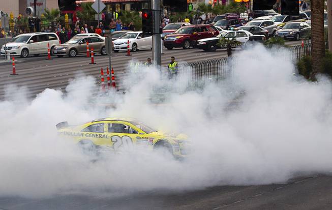 Matt Kenseth burns out at harmon Avenue during a NASCAR Victory Lap on the Las Vegas Strip Thursday, Dec. 4, 2014. The annual event is part of the NASCAR Champion's Week.