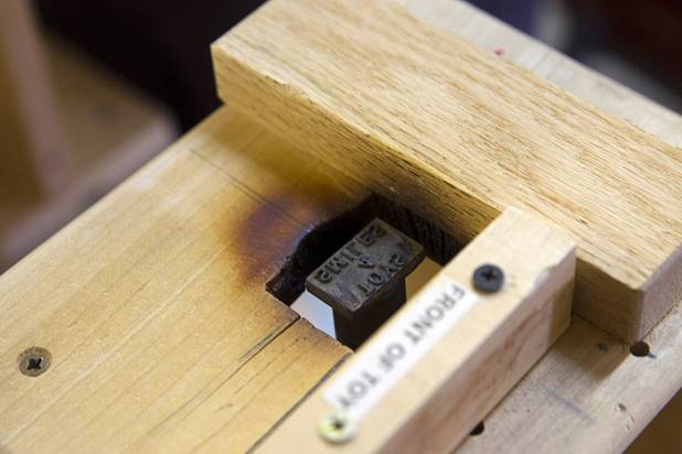An assembly station for burning the Toys 4 Smiles name on the bottom of toy cars is shown in the Toys 4 Smiles workshop Monday, Dec. 8, 2014. The nonprofit organization started as a wood club in 2006 and will soon produce their 200,000th toy, said founder Rex Doty.