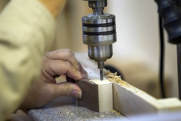 A volunteer uses a drill press to make axles holes in toy cars at the Toys 4 Smiles workshop Monday, Dec. 8, 2014. The nonprofit organization started as a wood club in 2006 and will soon produce their 200,000th toy, said founder Rex Doty.