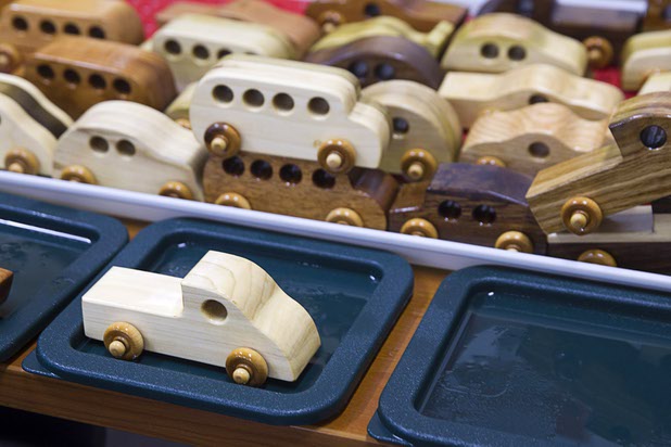 Toy cars dry after being dipped in mineral oil at the Toys 4 Smiles workshop Monday, Dec. 8, 2014. The nonprofit organization started as a wood club in 2006 and will soon produce their 200,000th toy, said founder Rex Doty.