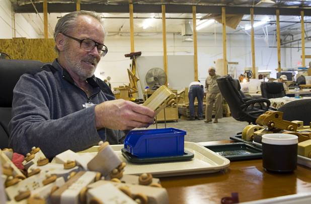 Chuck Hahn dips toy cars in mineral oil at the Toys 4 Smiles workshop Monday, Dec. 8, 2014. The nonprofit organization started as a wood club in 2006 and will soon produce their 200,000th toy, said founder Rex Doty.