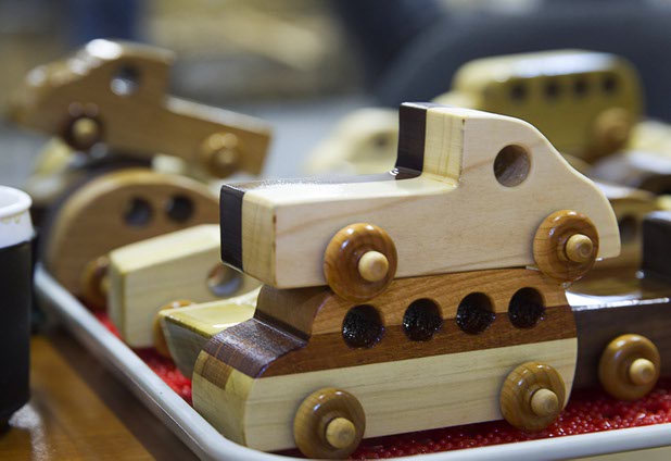 Toy cars dry after being dipped in mineral oil at the Toys 4 Smiles workshop Monday, Dec. 8, 2014. The nonprofit organization started as a wood club in 2006 and will soon produce their 200,000th toy, said founder Rex Doty.