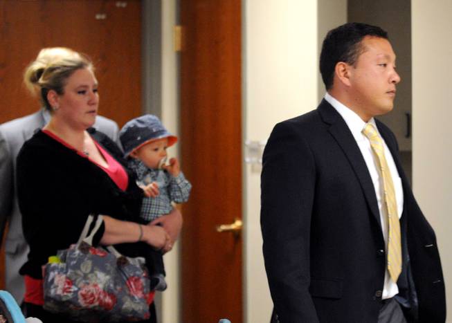 FILE - In this May 21, 2014 file photo, Marcus Kaarma, right, is followed into Missoula District Court by his wife Janelle with their child in Missoula, Mont. Jury selection began Monday, Dec. 1, 2014 in the trial of Kaarma, a Montana man charged with fatally shooting Diren Dede, a German exchange student who broke into his garage. 