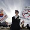 Cameron Cerf holds a protest sign with Southwest Airlines employees at the entrance to Love Field in Dallas, Tuesday, Dec. 16, 2014. Saying Southwest Airlines is neglecting workers and its customers, baggage handlers are bringing attention to the company's slide in on-time performance as they seek a new contract after three years of negotiations.