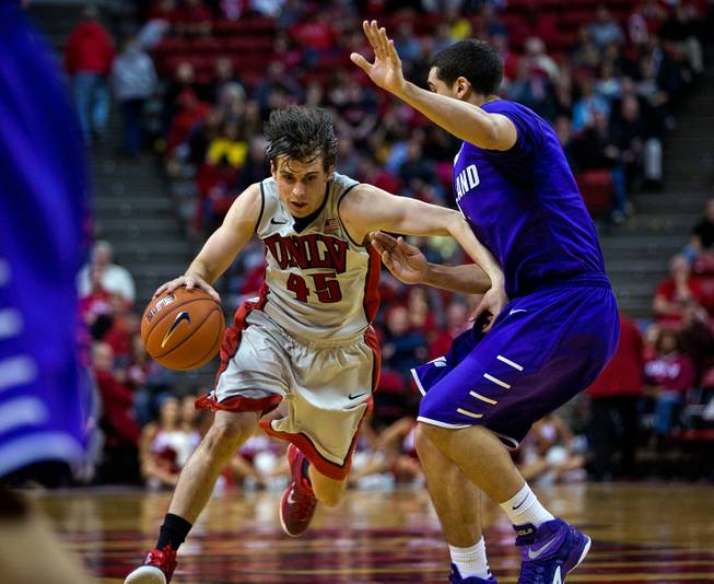 UNLV guard Cody Doolin (45) drives past Portland guard Bryce Pressley (1) on his way to a late-game basket at the Thomas & Mack Center on Wednesday, December 17, 2014.