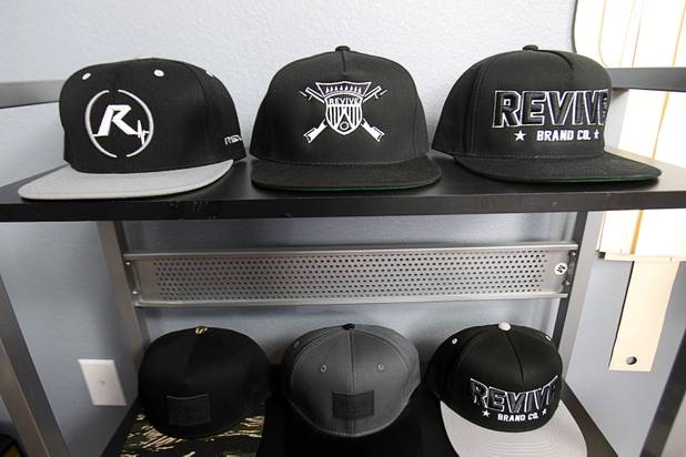 The Revive Brand Co. hats are displayed in the Revive home office Thursday, Dec. 18, 2014. From left:  Amanda Appling, creative director, Medin Gebrezgier, chief marketing officer, Cesar Santos, research and development/production manager, and Jonathan Santos, CEO.