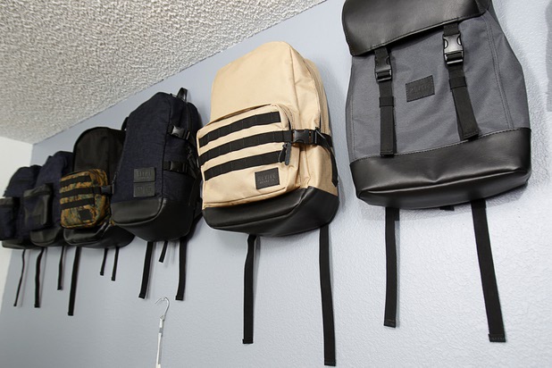 The Revive Brand Co. backpacks are displayed in the Revive home office Thursday, Dec. 18, 2014. From left:  Amanda Appling, creative director, Medin Gebrezgier, chief marketing officer, Cesar Santos, research and development/production manager, and Jonathan Santos, CEO.