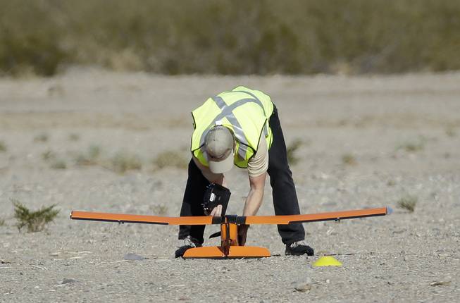 Scott Carrigan of Sensurion Aerospace picks up the company's Magpie commercial drone after it crashed during launch Friday, Dec. 19, 2014, near Boulder City.