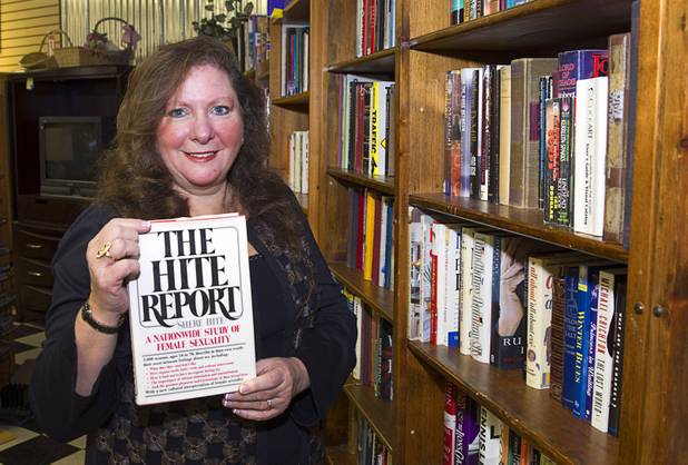 Michele Morgan-Devore, executive director of the nonprofit Dinosaurs & Roses thrift shop, 4310 E. Tropicana Ave., displays a book at the store Tuesday, Dec. 23, 2014.