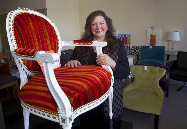 Michele Morgan-Devore, executive director of the nonprofit Dinosaurs & Roses thrift shop, 4310 E. Tropicana Ave., poses with new furniture donated by the World Market Center at the store Tuesday, Dec. 23, 2014.