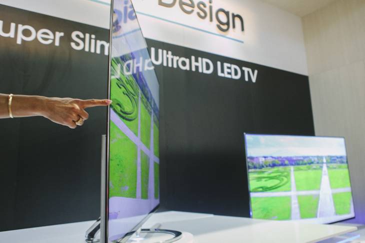 A representative demonstrates how slim the new 4K UltraHD LED TV by Sharp is on display at CES 2015 in the Las Vegas Convention Center on Wednesday, January 7, 2015.