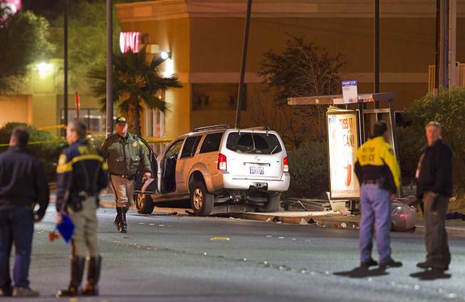 Metro Police and crime scene analysts investigate an accident Saturday, Jan. 10, 2015, after an SUV crashed into a bus stop, striking a woman and two children on Rainbow Boulevard north of Lake Mead Boulevard.