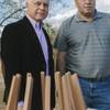 Andy Armenian, left, and Levon Gulbenkian, right, stand next to a model of the Armenian Genocide Monument at Sunset Park, where the sculpture will be built.