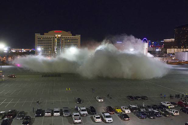 A dust cloud drifts across the parking lot as the Clarion Hotel and Casino is imploded early Tuesday morning, Feb. 10, 2015. The hotel, opened in 1970, was once owned by actress Debbie Reynolds and named the Debbie Reynolds Hollywood Hotel. A mixed-use resort, catering to convention-goers, is planned for the site, according to developer Lorenzo Doumani.