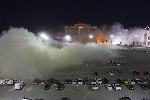 A dust cloud drifts across the parking lot as the Clarion Hotel and Casino is imploded early Tuesday morning, Feb. 10, 2015. The hotel, opened in 1970, was once owned by actress Debbie Reynolds and named the Debbie Reynolds Hollywood Hotel. A mixed-use resort, catering to convention-goers, is planned for the site, according to developer Lorenzo Doumani.