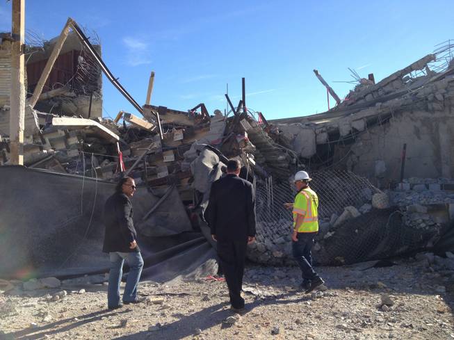 Ofir Hagay of WGH Partners, David Pyle of Krausz Companies and Ken Mercurio of Diversified Demolition Co. inspect the rubble of the Gramercy's nine-story residential tower shortly after the southwest Las Vegas building was imploded Sunday, Feb. 15, 2015.