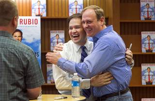 U.S. Sen. Marco Rubio, left, (R-Fla.) gets a hug from childhood friend Bryan Thiriot during his 