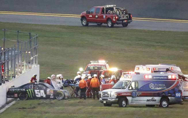 Kyle Busch, center, is taken to an ambulance on a stretcher after he was involved in a multicar crash during the Xfinity Series auto race at Daytona International Speedway, Saturday, Feb. 21, 2015, in Daytona Beach, Fla.