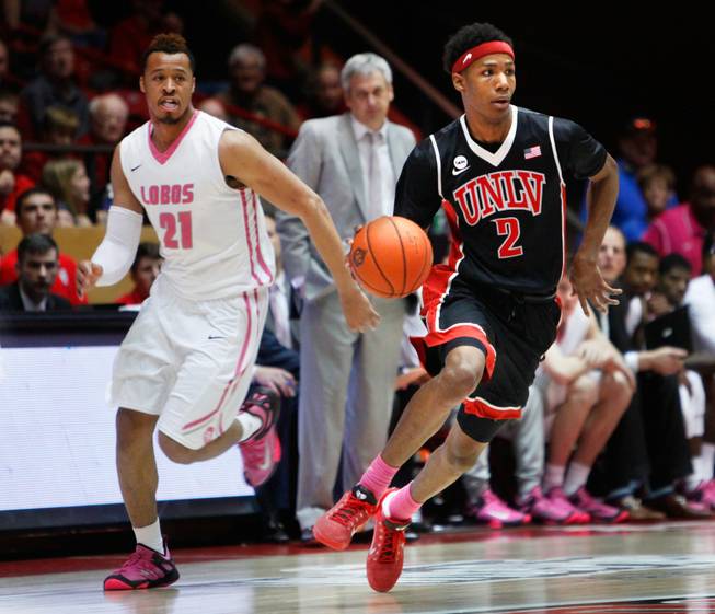 UNLV guard Patrick McCaw dribbles past New Mexico's Xavier Adams during the second half of an NCAA college basketball game Saturday, Feb. 21, 2015, in Albuquerque.