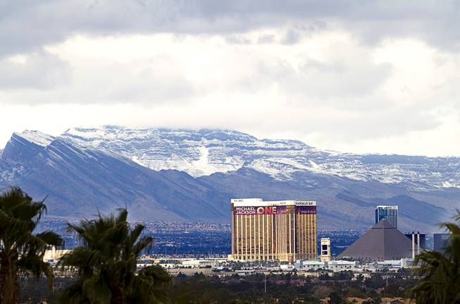 Snow-covered mountains are shown behind the Mandalay Bay and Luxor casinos Monday, Feb. 23, 2015. The Las Vegas Ski and Snowboard Resort on Mount Charleston received 10 inches of new snow, according to the weather service. 