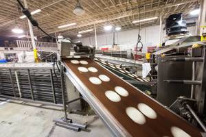 Tortilla dough travels along conveyer belts to the ovens at Tortillas Incorporated, a family-owned tortilla factory, in North Las Vegas January 22, 2015.