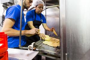 Danelia Gonzalez, right, and a co-worker load freshly made tortillas into the tostada oven while working at Tortillas Incorporated, a family-owned tortilla factory, in North Las Vegas January 22, 2015.