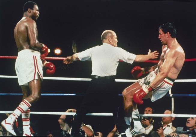 Gerry Cooney, right, begins to fall to the canvas during the 13th round of the World Heavyweight Championship bout against Larry Holmes, June 12, 1982, in Las Vegas.  Holmes is held back by referee Mills Lane.  (AP Photo)