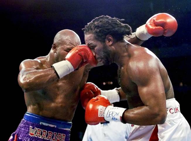 Evander Holyfield, left, hits Lennox Lewis with a right during the seventh round of their undisputed world heavyweight championship bout at the Thomas & Mack Center in Las Vegas Saturday, Nov. 13, 1999. Lewis won the bout by way of unanimous decision after 12 rounds. (AP Photo/Eric Draper)