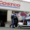 In this Dec. 7, 2011, file photo, a shopper leaves Costco in Portland, Ore.