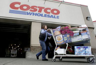 In this Dec. 7, 2011, file photo, a shopper leaves Costco in Portland, Ore.