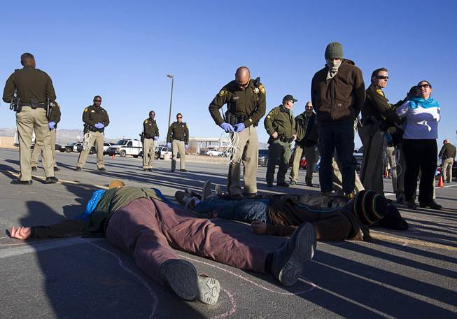 Protesters are arrested after staging a "die-in" during an anti-drone protest at Creech Air Force Base, about 50 miles northwest of Las Vegas, on Friday, March 6, 2015. About 100 people came out for the protest organized by the peace group CODEPINK.