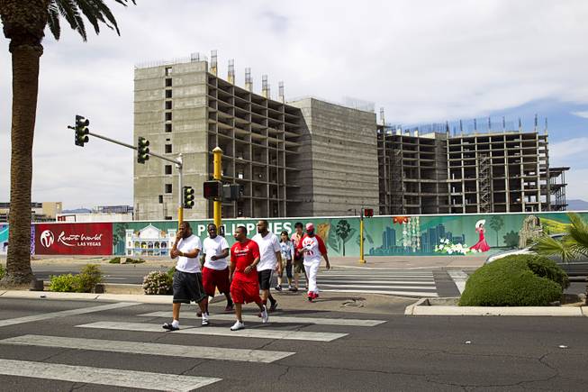 Pedestrian cross Las Vegas Boulevard Sunday, March 22, 2015. In the background is the uncompleted Echelon casino project. The Maylasia-based Genting Group bought the site and announced plans for Resorts World Las Vegas in March 2013.