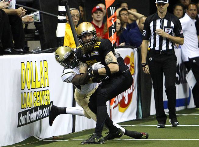 Virgil Gray (4) takes down Outlaws' Tysson Poots (19) during the Outlaws' inaugural game against the San Jose SaberCats at the Thomas & Mack Center Monday, March 30, 2015.