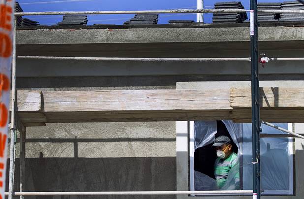 A carpenter works on an apartment complex at Hualapai and Peace Ways Tuesday, April 7, 2015.