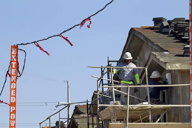 Carpenters work on an apartment complex under construction at Hualapai and Peace Ways Tuesday, April 7, 2015.