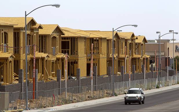 A vehicle drives by an apartment complex under construction at Peace and Hualapai ways in the Southwest valley Sunday, April 5, 2015.