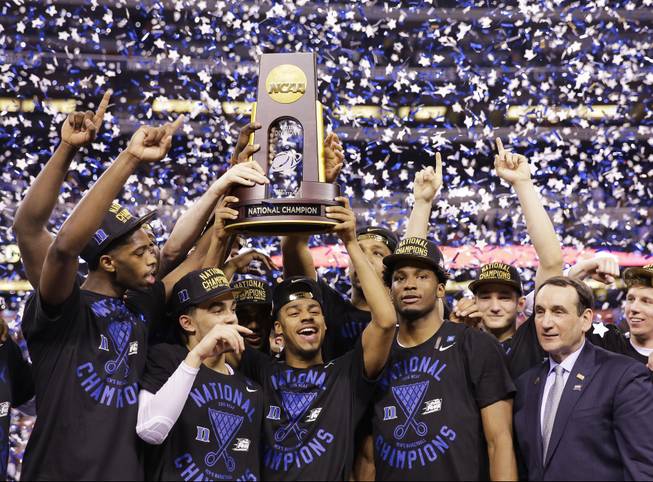 Duke players and head coach Mike Krzyzewski hold up the championship trophy after Duke defeated Wisconsin to win the NCAA Tournament on Monday, April 6, 2015, in Indianapolis. Duke won 68-63 to claim the title.