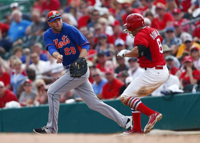 St. Louis Cardinals center fielder Peter Bourjos is safe as New York Mets utility man Eric Campbell covers first base after a wild pitch on a third strike call during a spring training game Friday, March 27, 2015, in Jupiter, Fla.