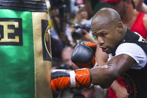 WBC/WBA welterweight champion Floyd Mayweather Jr. hits a heavy bag at the Mayweather Boxing Club Tuesday, April 14, 2015. Mayweather will face WBO welterweight champion Manny Pacquiao of the Philippines in a unification bout at the MGM Grand Garden Arena on May 2.  .